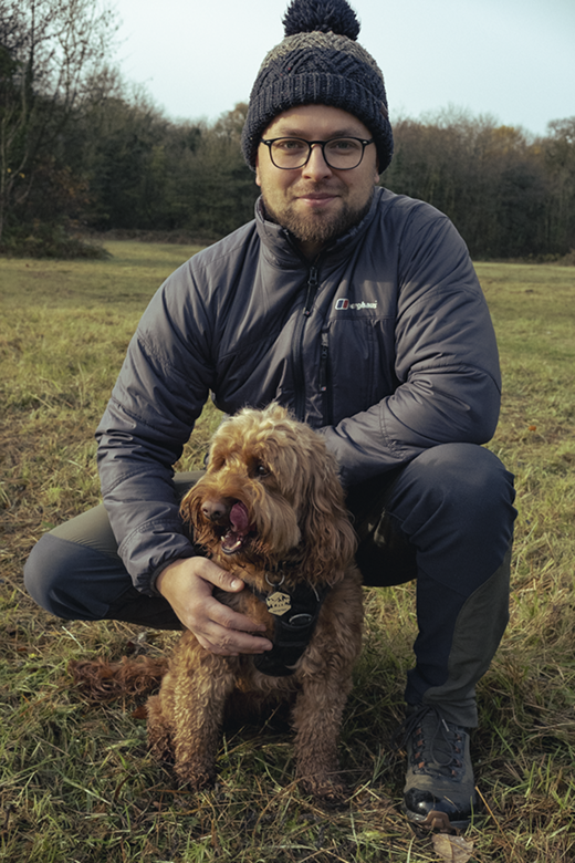 Image of me in my walking gear kneeling with my dog in a field on a cold winters day